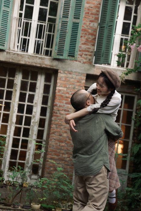 Sơn bế bổng Hoa trước ngôi nhà gạch